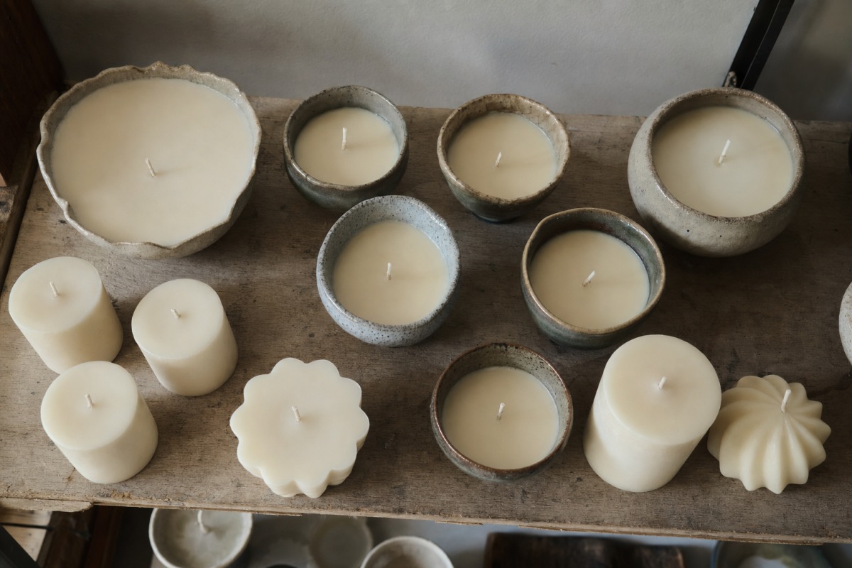 Bougies fraîchement coulées en train de durcir sur une étagère de l'atelier