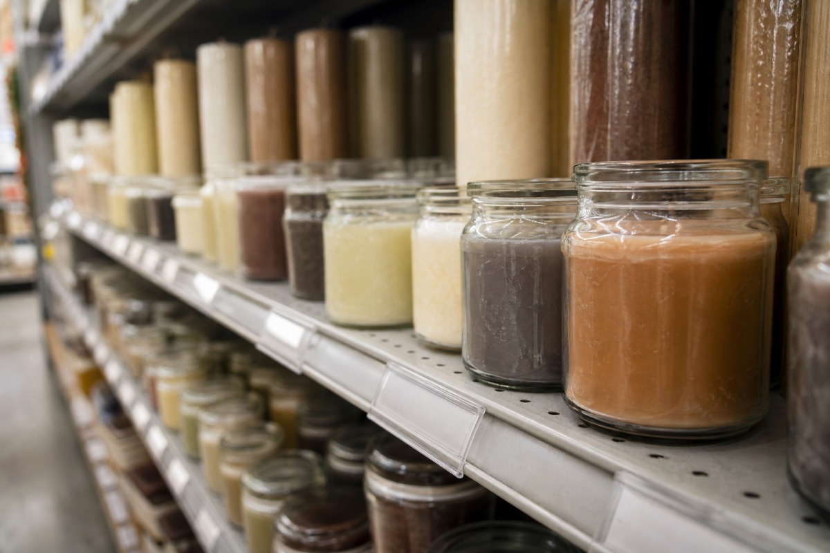Rangée de bougies bon marché dans de simples verres sur un rayon de drugstore